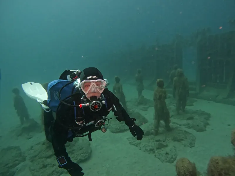 Plongeur en combinaison noire explore un site archéologique sous-marin