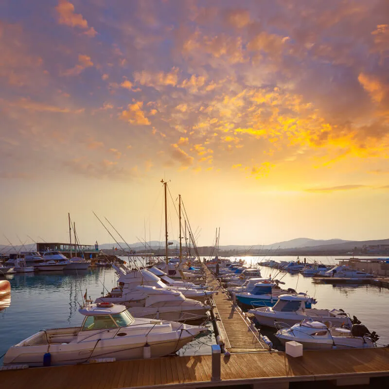 Port de plaisance avec bateaux amarrés au coucher du soleil doré