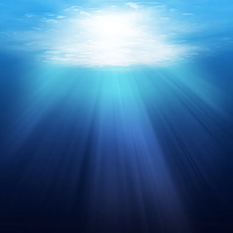 Rayons de soleil perçant la surface de l'eau en plongée