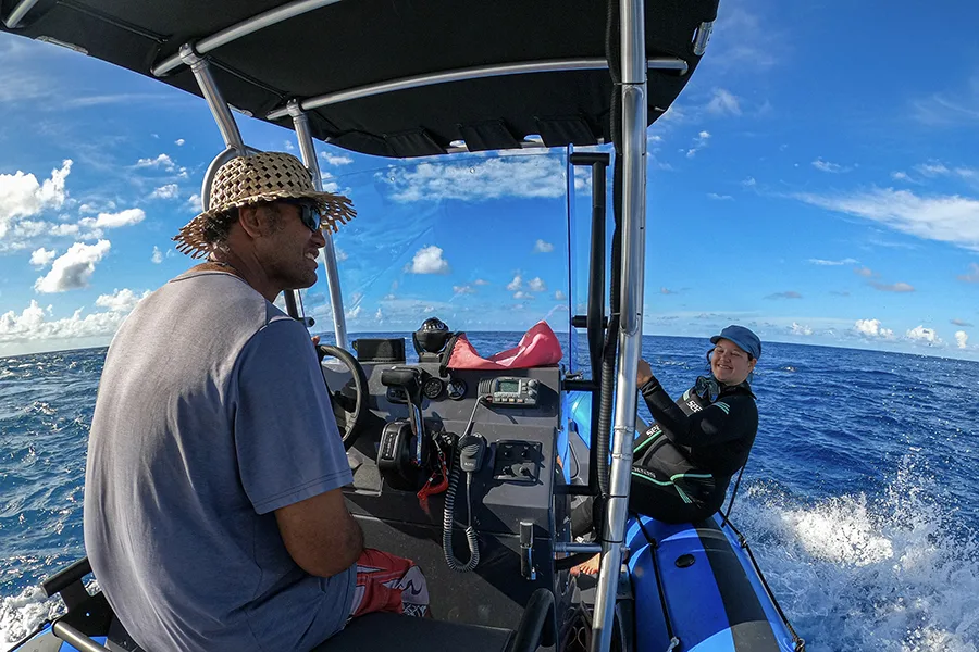 Deux personnes à bord d'un semi-rigide en pleine mer, ciel bleu