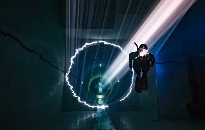 Plongeur évoluant dans un tunnel lumineux artificiel sous-marin