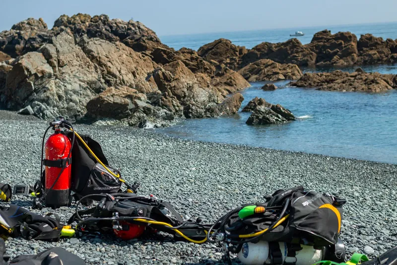 Equipement de plongée sur une plage de galets face à la mer