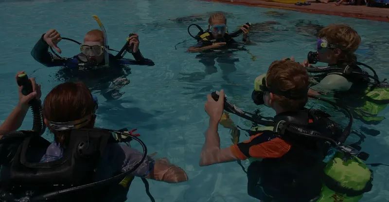 Groupe de personnes en formation de plongée dans une piscine
