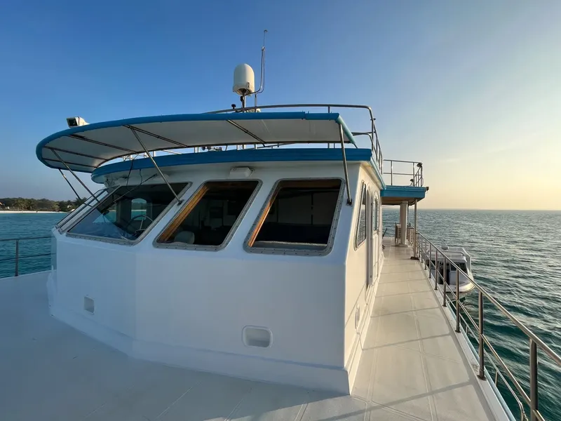 Bateau de plongée blanc et bleu naviguant sur une mer calme
