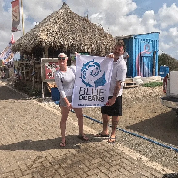Deux personnes souriantes tiennent une bannière avec un logo bleu