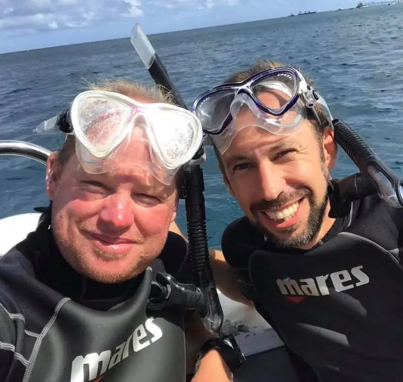 Deux plongeurs souriants avec masque et tuba sur un bateau