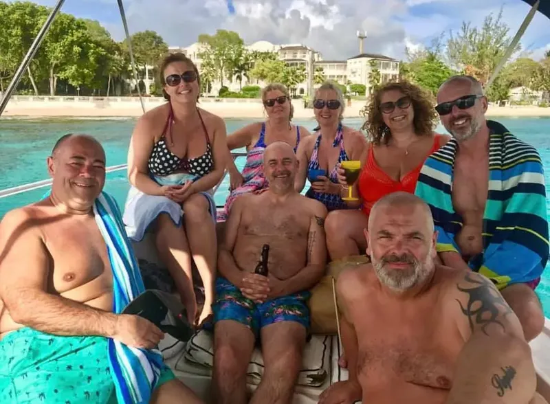 Groupe de personnes souriantes sur un bateau en mer, journée ensoleillée