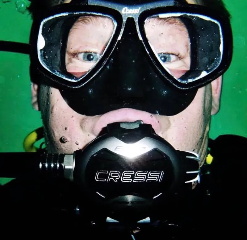 Plongeur avec masque et détendeur, regardant la caméra sous l'eau