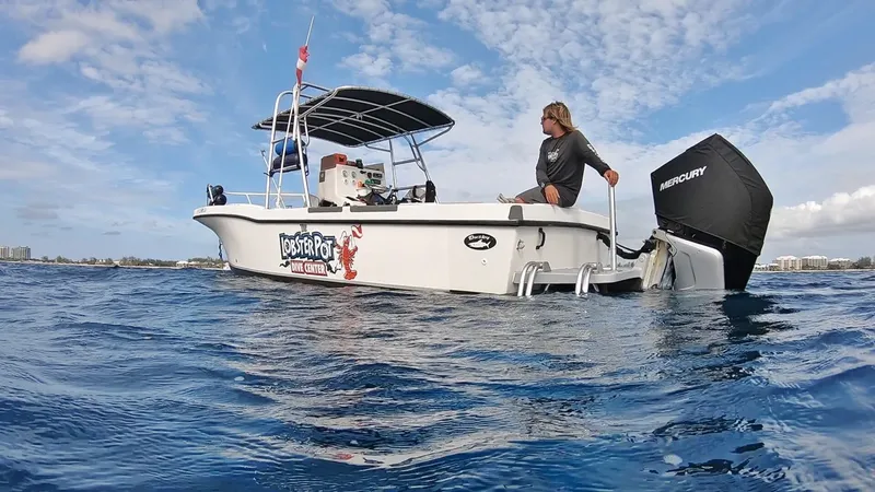 Bateau de plongée blanc avec une personne assise en mer calme