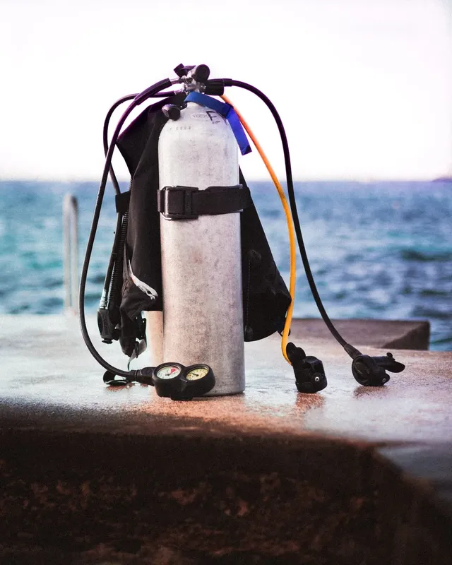 Equipement de plongée complet posé sur un quai en béton face à la mer