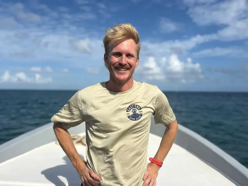 Homme souriant sur un bateau en mer, temps ensoleillé