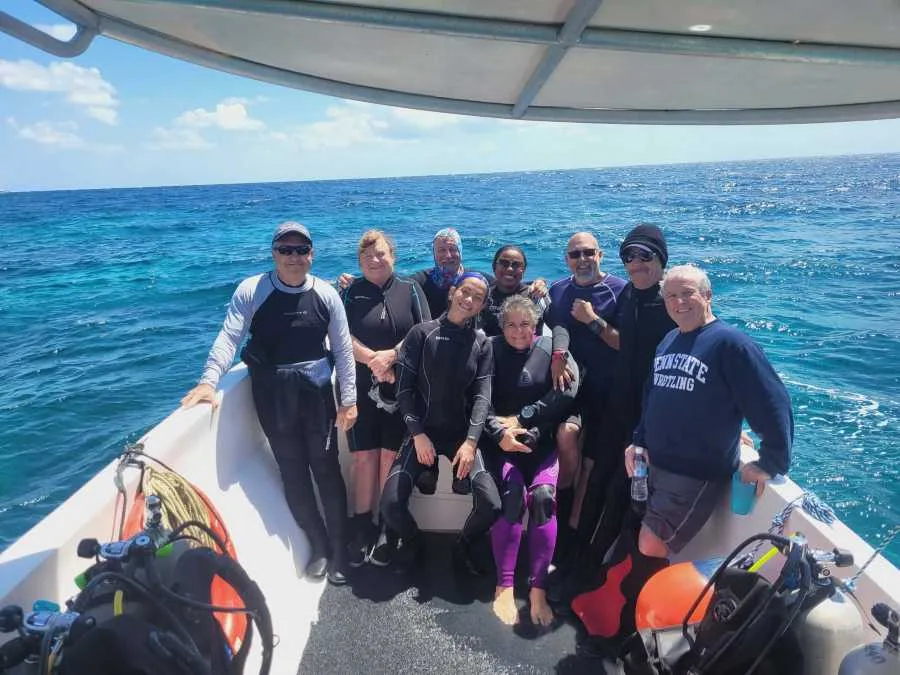 Groupe de plongeurs souriants à bord d'un bateau en mer