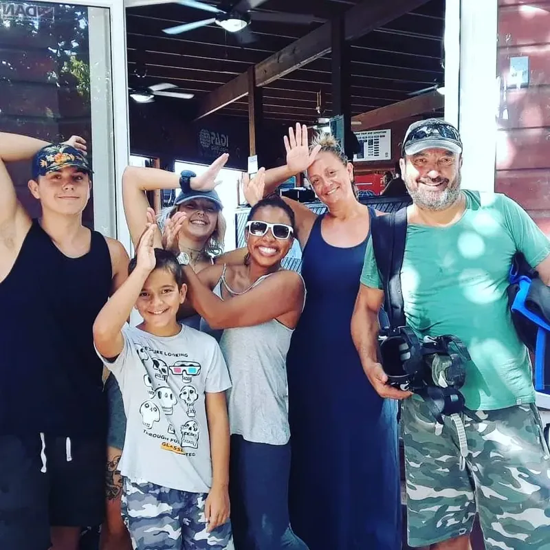 Groupe de personnes souriantes devant un centre de plongée