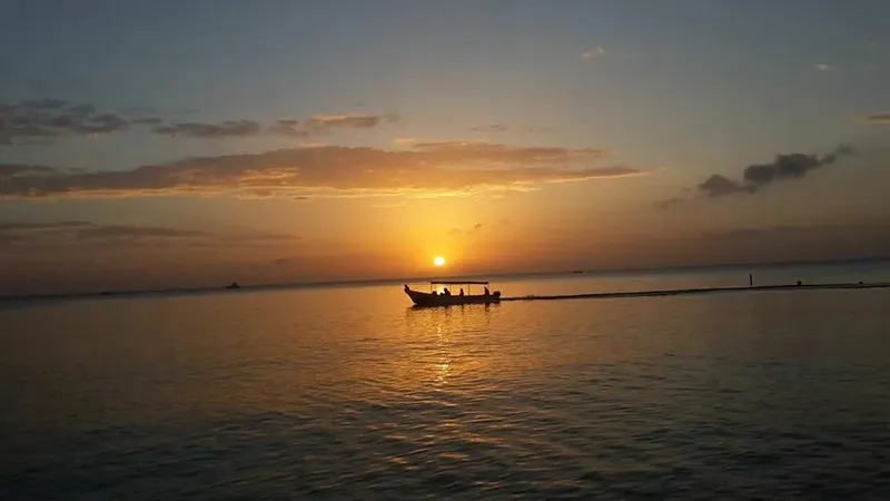 Bateau de pêche au coucher du soleil sur une mer calme