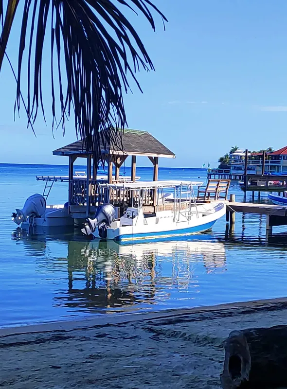 Bateau de plongée amarré à un ponton en bois sous le soleil