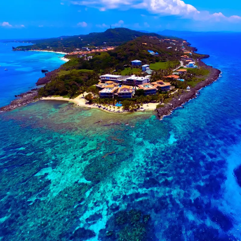 Vue aérienne d'une île tropicale avec bâtiments et récifs coralliens
