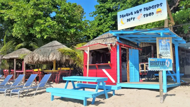 Boutique de plongée colorée sur une plage de sable avec mobilier extérieur