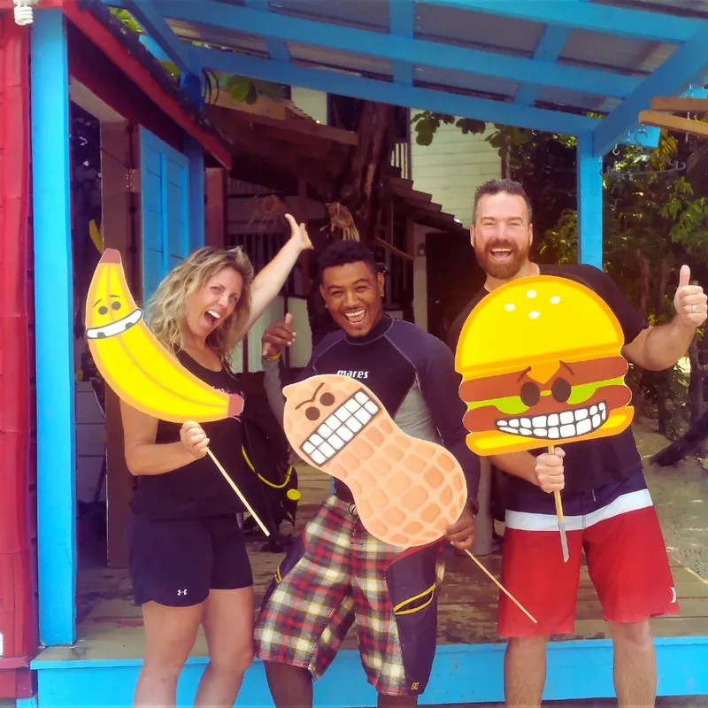 Trois personnes souriantes posent avec des accessoires alimentaires colorés