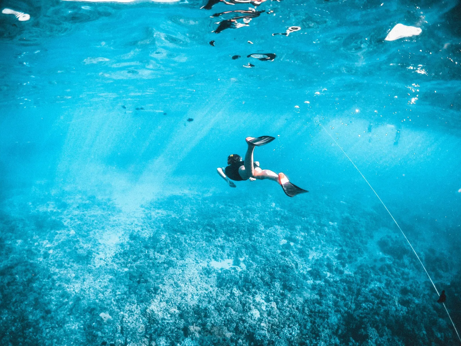 Une personne nageant en apnée dans une eau turquoise et claire