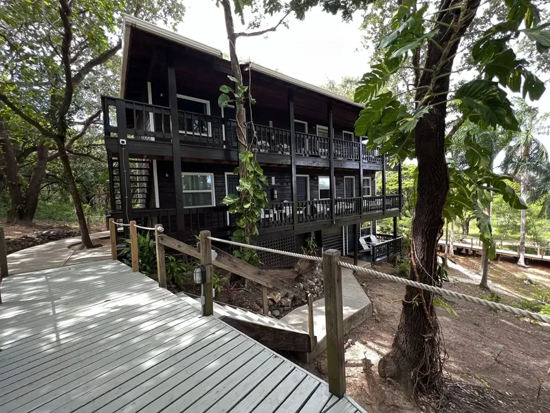 Bâtiment en bois sombre avec terrasse, accès par un ponton en bois