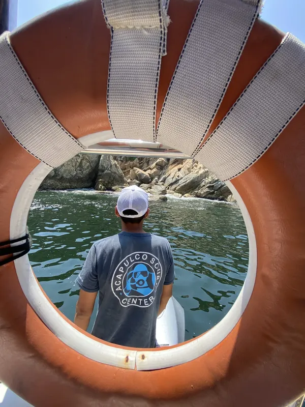 Homme regardant la mer depuis un bateau avec un logo visible