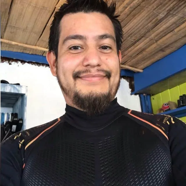 Portrait d'un homme souriant portant une combinaison de plongée noire