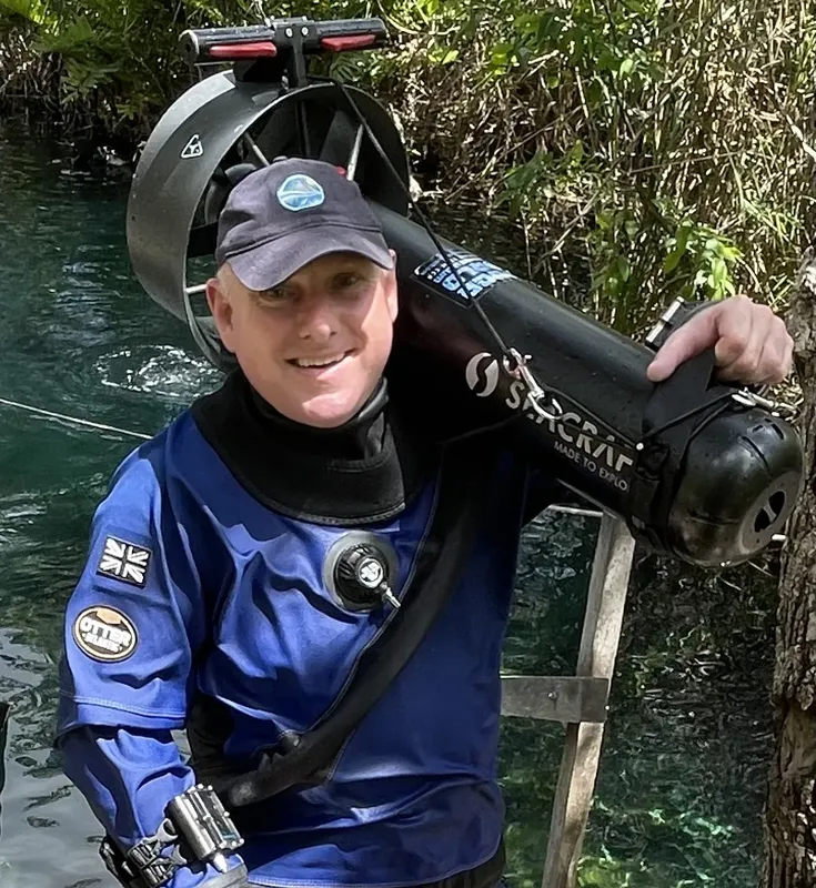 Plongeur souriant avec son scooter des mers et son équipement