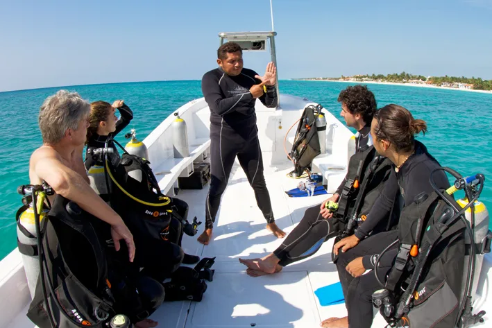 Plongeurs sur un bateau, briefing avant une immersion en mer