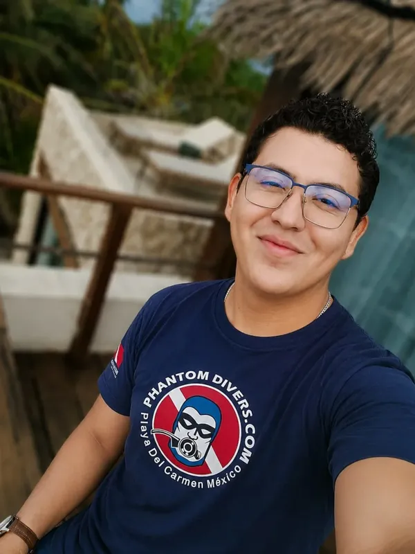 Portrait d'un homme souriant portant un t-shirt avec un logo de plongée