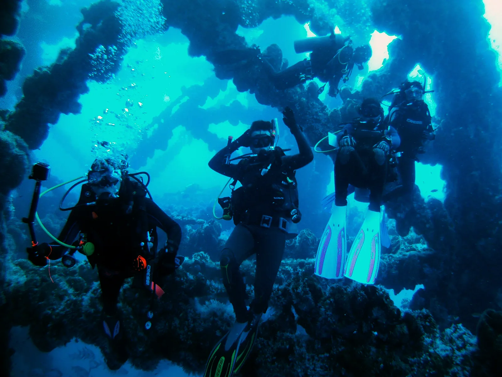 Groupe de plongeurs explore une grotte sous-marine bleu profond