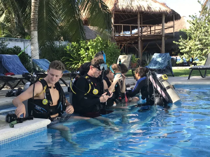 Groupe de plongeurs en formation dans une piscine ensoleillée