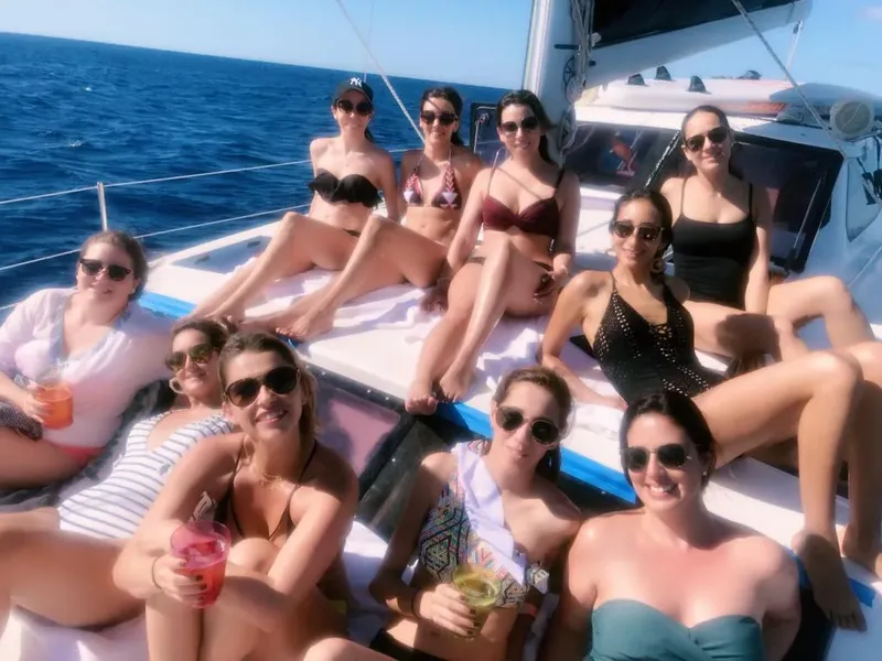 Groupe de femmes souriantes se relaxant au soleil sur un bateau