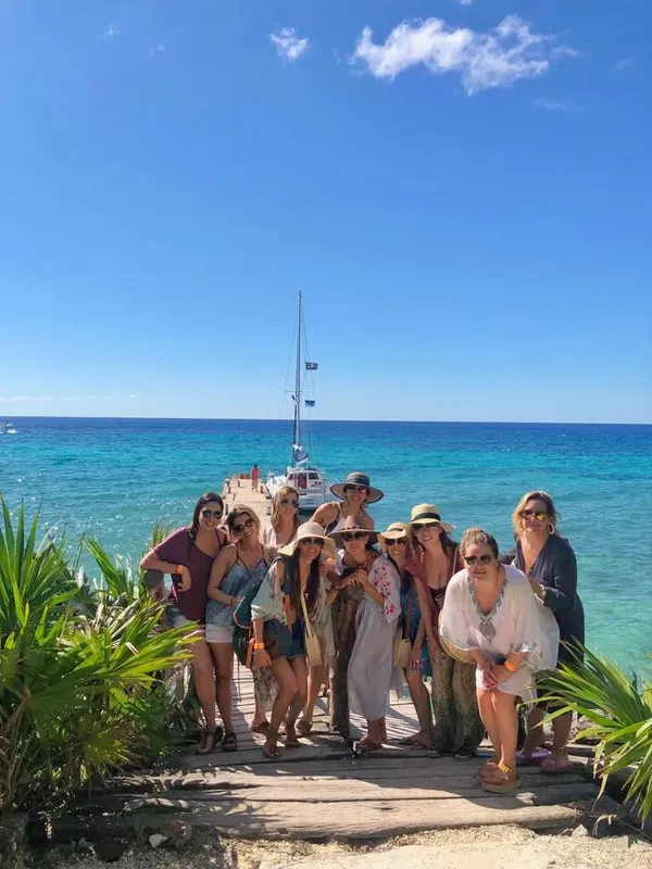 Groupe de personnes souriantes sur un ponton en bord de mer