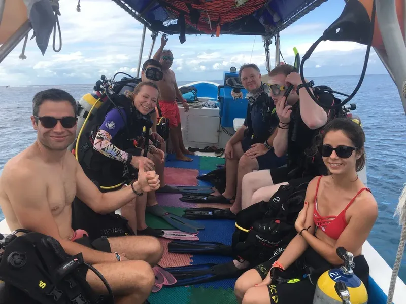 Groupe de plongeurs souriants sur un bateau de plongée en mer