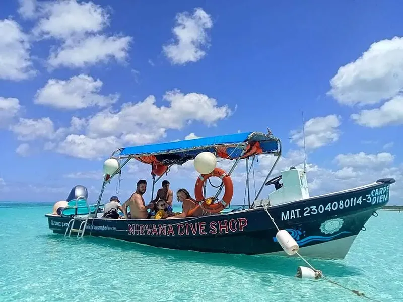Bateau de plongée bleu et orange avec des passagers en mer