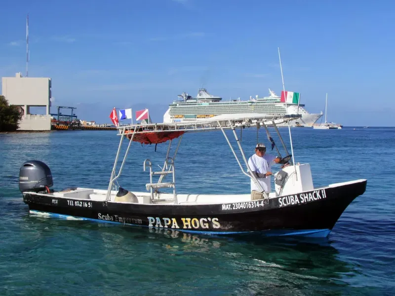 Bateau de plongée noir en mer avec un homme à bord