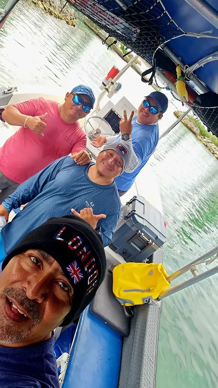 Quatre personnes souriantes sur un bateau de plongée en mer