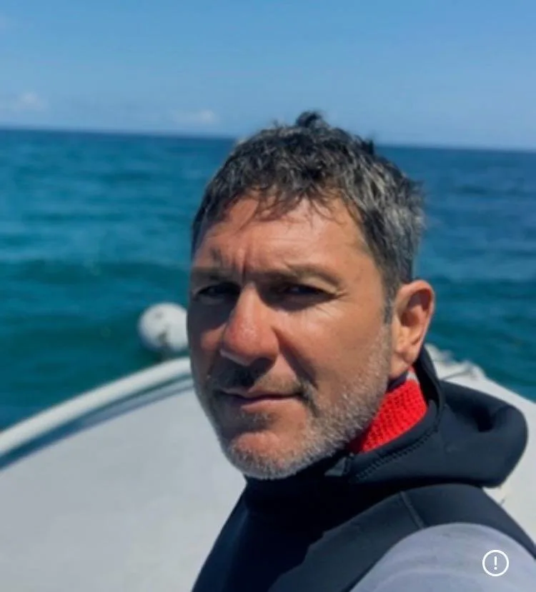 Portrait d'un homme sur un bateau en mer, regardant la caméra