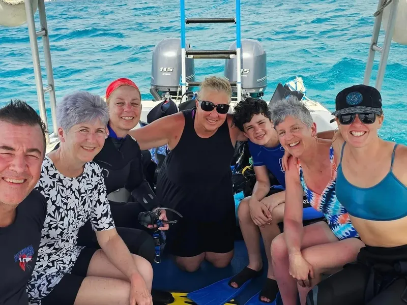 Groupe de plongeurs souriants à bord d'un bateau en mer
