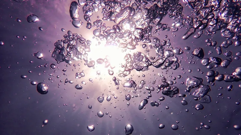 Bulles d'air remontant vers la surface sous l'eau lumière diffuse
