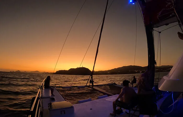Coucher de soleil en mer avec des personnes à bord d'un bateau