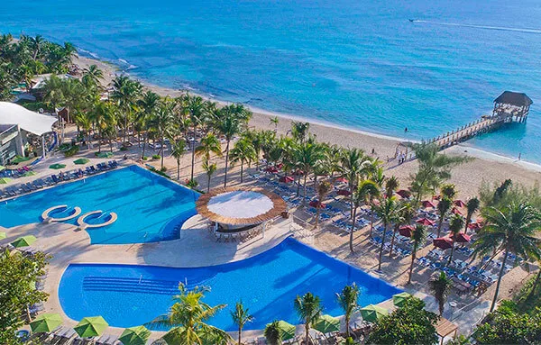 Vue aérienne d'un complexe hôtelier avec piscine et ponton sur plage
