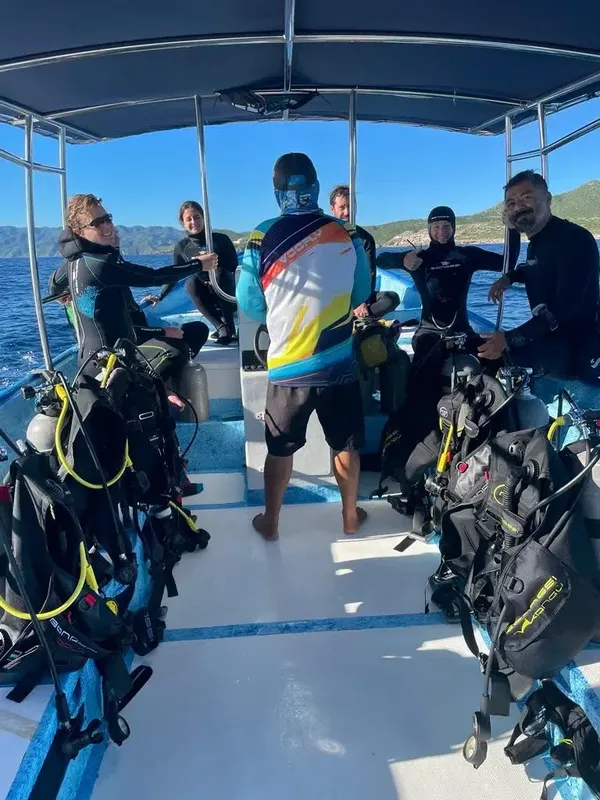 Groupe de plongeurs équipés sur un bateau en mer ensoleillée
