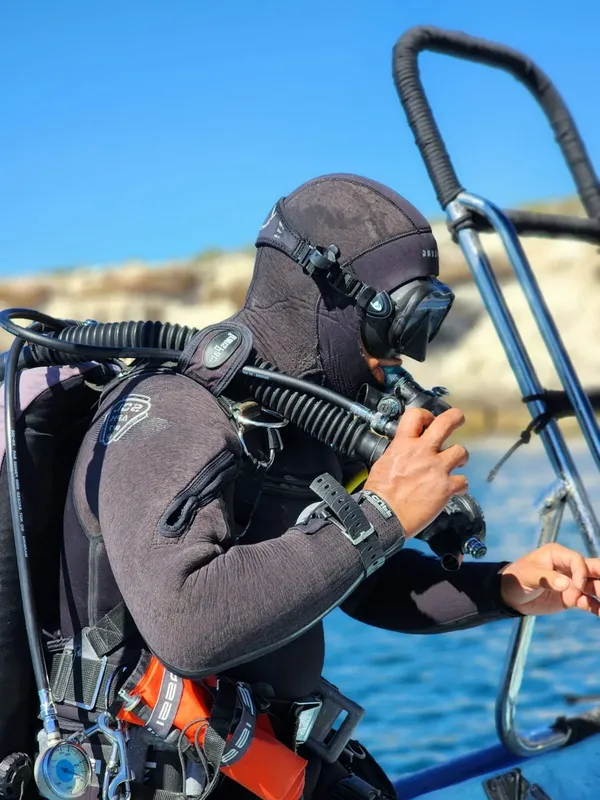 Plongeur préparant son équipement à bord d'un bateau ensoleillé