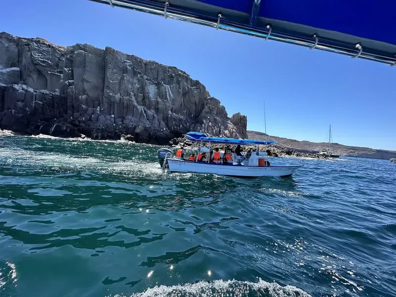 Bateau de plongée en mer avec des passagers et une côte rocheuse