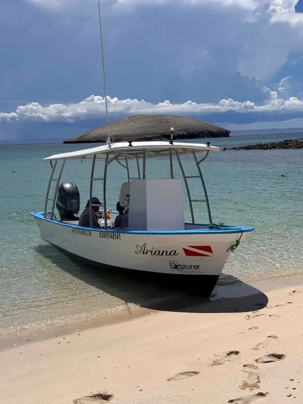 Bateau de plongée échoué sur une plage de sable clair