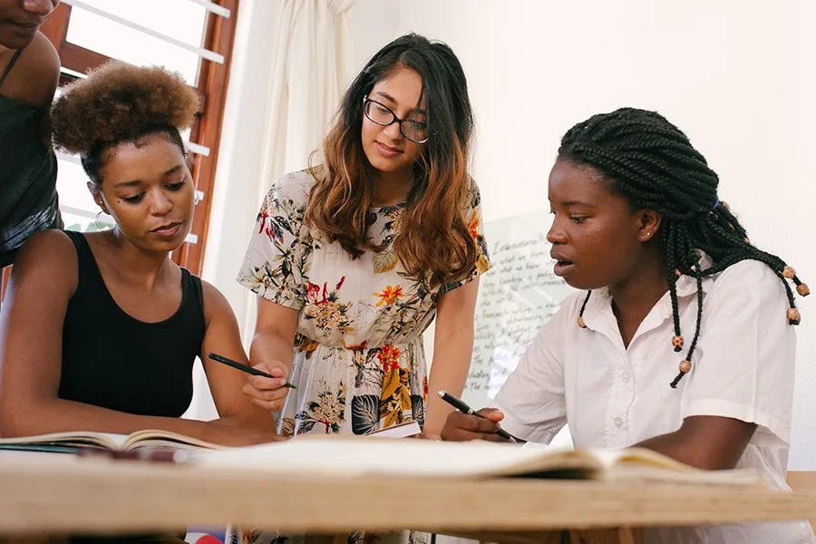 Trois femmes discutent et prennent des notes autour d'une table