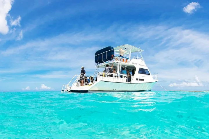 Bateau de plongée avec des passagers, mer turquoise et ciel bleu