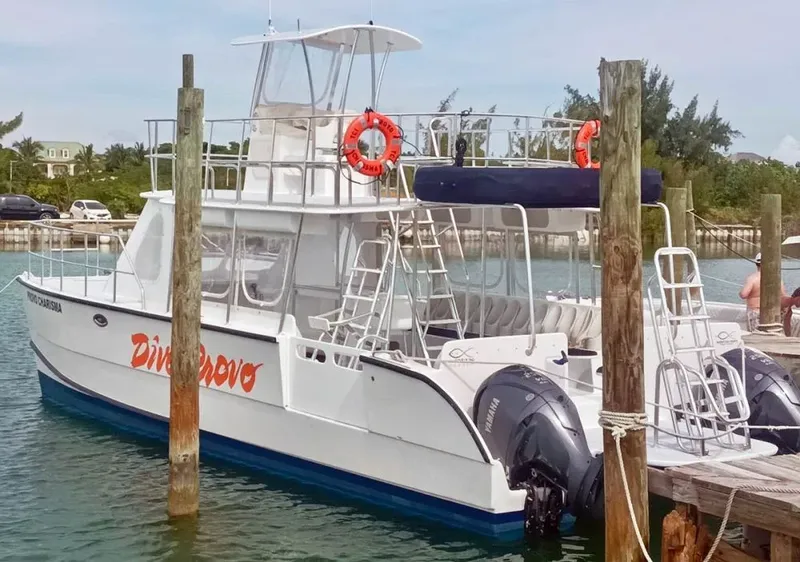 Bateau de plongée amarré à un ponton en bois sous le soleil