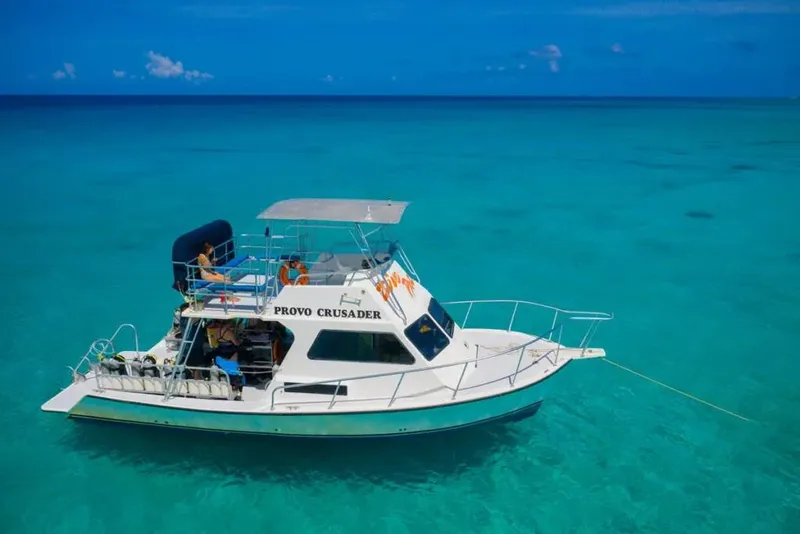 Bateau de plongée blanc et bleu sur une mer turquoise claire